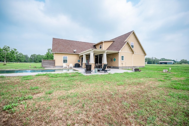 rear view of property featuring a patio and a lawn