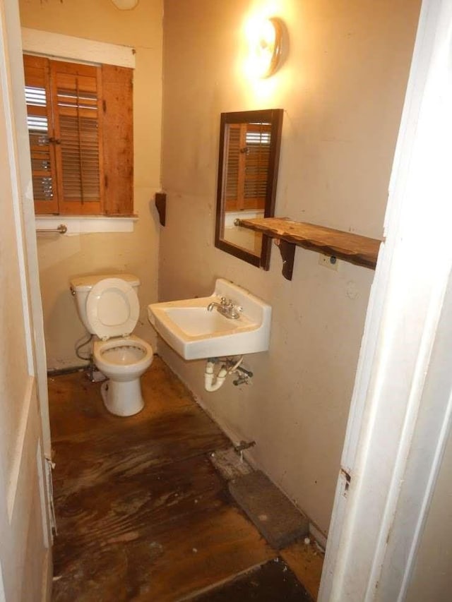 6636 Ave P, Houston, TX 77011 - half bathroom featuring toilet, a sink, and wood finished floors