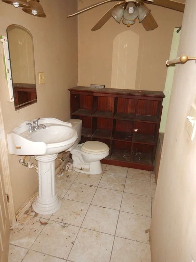 bathroom with tile flooring, ceiling fan, and toilet