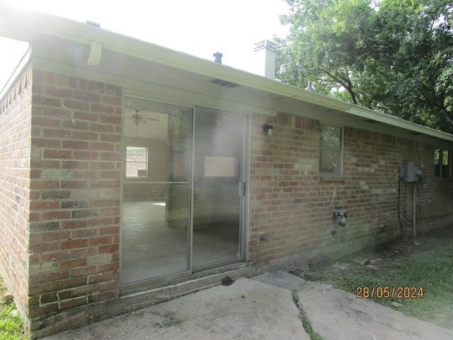 12515 Cooperstown Dr, Houston, TX 77089 - view of exterior entry featuring brick siding and a chimney