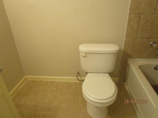 12515 Cooperstown Dr, Houston, TX 77089 - full bath with a bathtub, toilet, tile patterned flooring, baseboards, and a textured wall