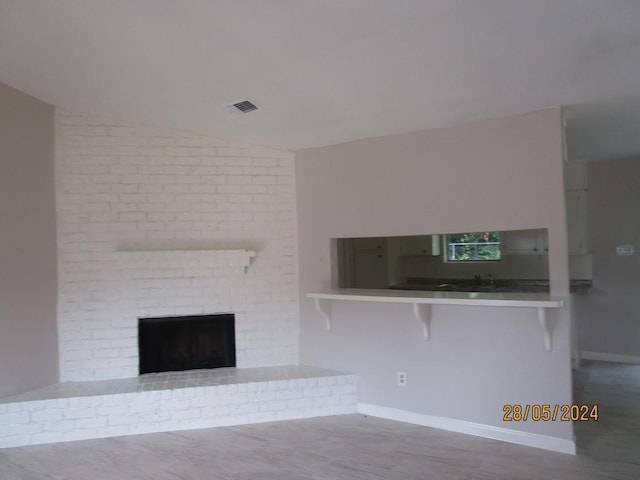 12515 Cooperstown Dr, Houston, TX 77089 - unfurnished living room featuring wood finished floors, a brick fireplace, baseboards, and lofted ceiling