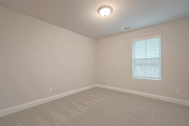 unfurnished room featuring carpet and a textured ceiling