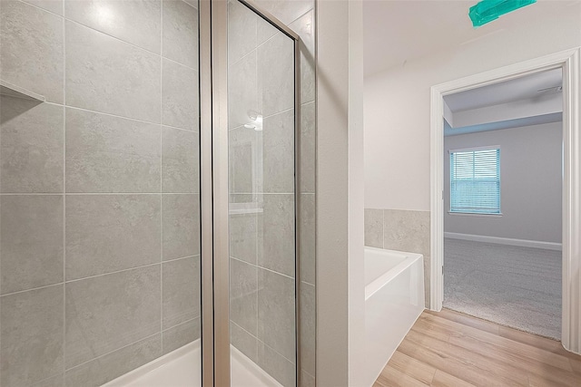 bathroom featuring hardwood / wood-style flooring and separate shower and tub