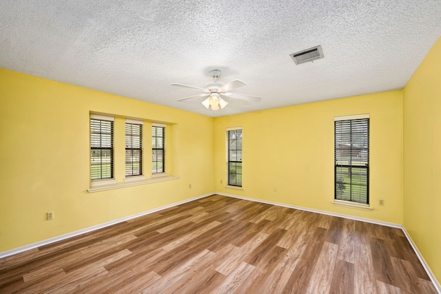 unfurnished room featuring ceiling fan, hardwood / wood-style floors, and a textured ceiling