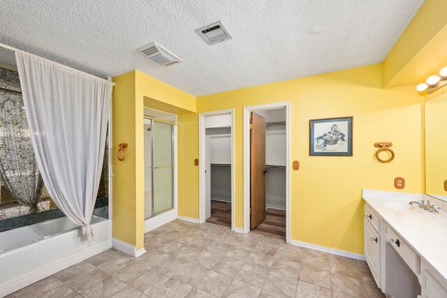 bathroom featuring vanity, shower with separate bathtub, and a textured ceiling