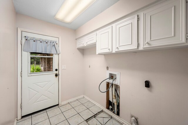 washroom featuring cabinets, hookup for a washing machine, light tile patterned floors, and electric dryer hookup