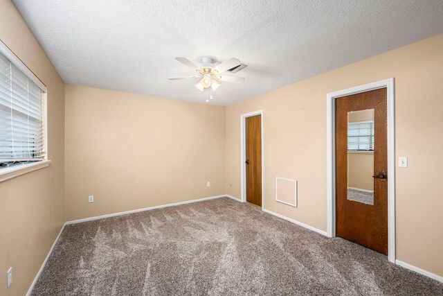 empty room with ceiling fan, carpet floors, and a textured ceiling