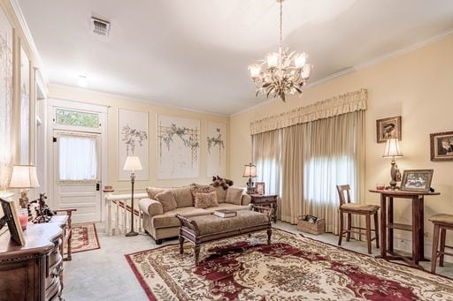 living room featuring a notable chandelier and ornamental molding