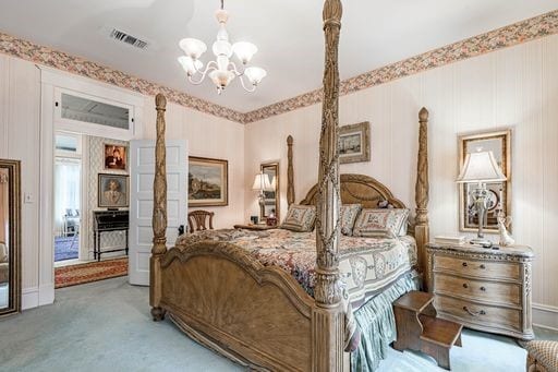 carpeted bedroom with a chandelier