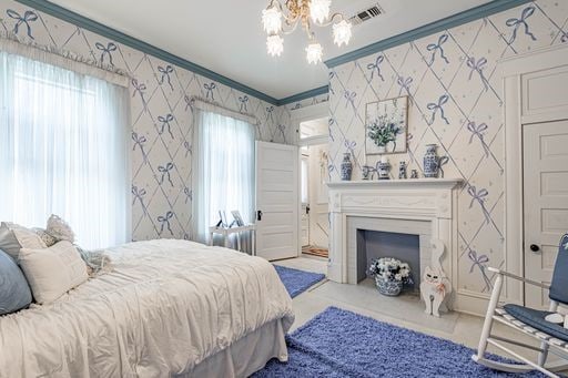 carpeted bedroom with a notable chandelier and crown molding