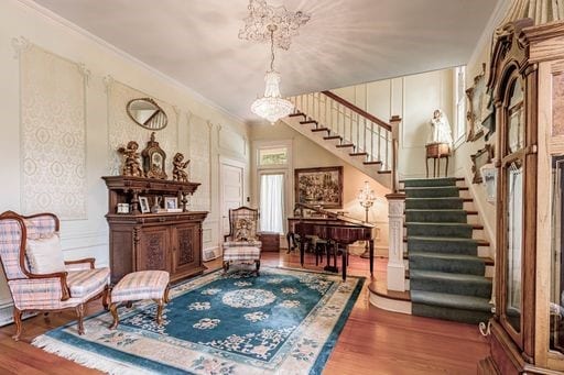 sitting room featuring a notable chandelier, hardwood / wood-style flooring, and ornamental molding