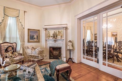 sitting room featuring hardwood / wood-style floors, a tiled fireplace, and ornamental molding