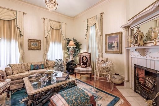 living room featuring light hardwood / wood-style floors, ornamental molding, and a fireplace