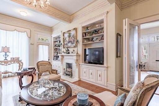 living room with an inviting chandelier, built in shelves, and light wood-type flooring