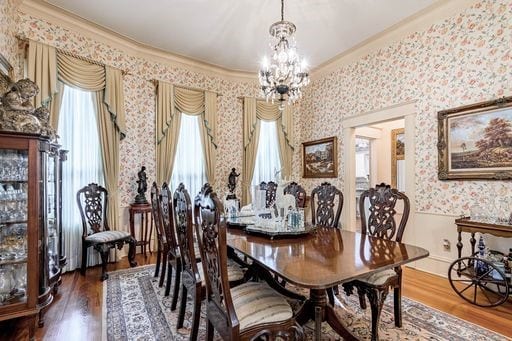 dining room featuring crown molding, hardwood / wood-style flooring, and a chandelier