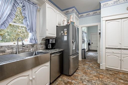 kitchen with sink, white cabinets, and appliances with stainless steel finishes