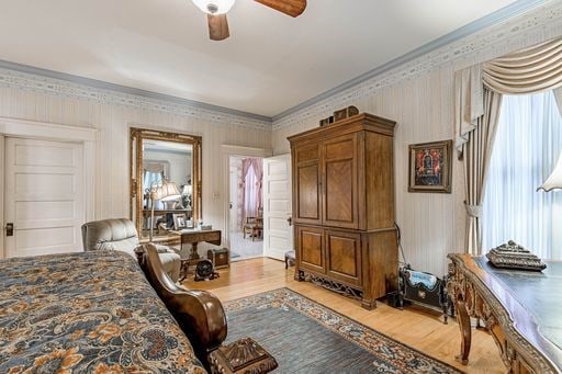 bedroom with multiple windows, crown molding, light wood-type flooring, and ceiling fan