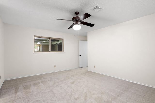 carpeted spare room with ceiling fan and a textured ceiling