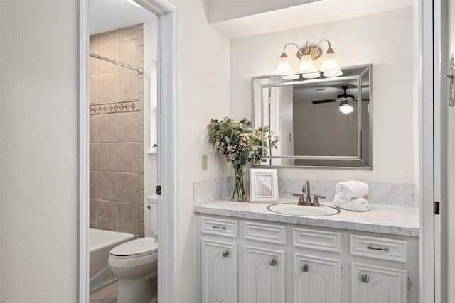 full bathroom featuring ceiling fan, toilet, vanity, and tiled shower / bath