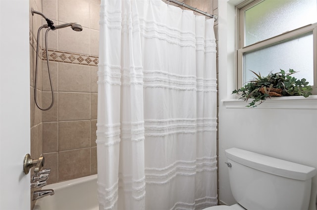 bathroom featuring shower / tub combo with curtain and toilet