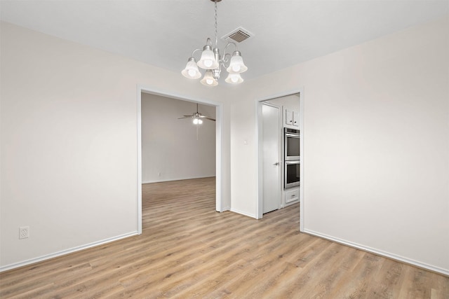 spare room featuring ceiling fan with notable chandelier and light wood-type flooring