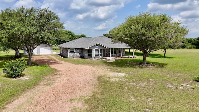 view of front of home featuring a front lawn, a garage, an outbuilding, covered porch, and driveway