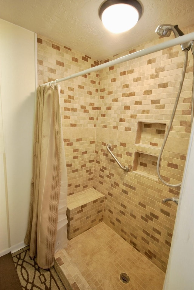 full bath featuring a textured ceiling and a stall shower