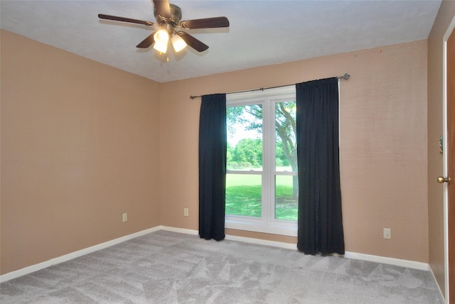 spare room featuring baseboards, a ceiling fan, and light colored carpet