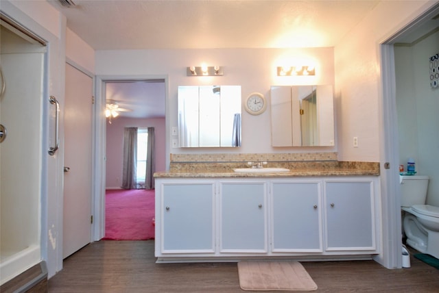 full bath with vanity, wood finished floors, and toilet