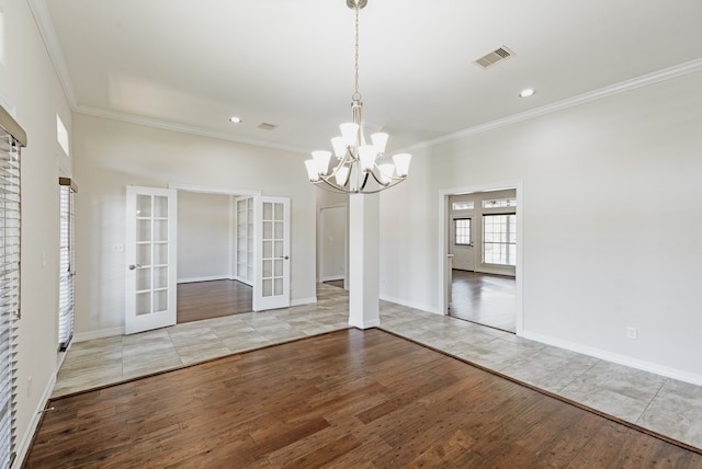 unfurnished dining area with tile flooring, a chandelier, french doors, and ornamental molding