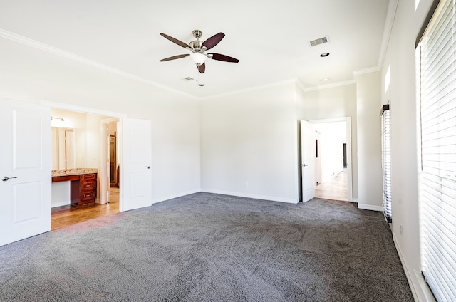 unfurnished bedroom with ornamental molding, carpet flooring, ensuite bathroom, and multiple windows