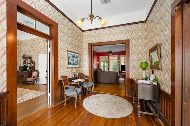 entrance foyer with hardwood / wood-style floors and ceiling fan with notable chandelier