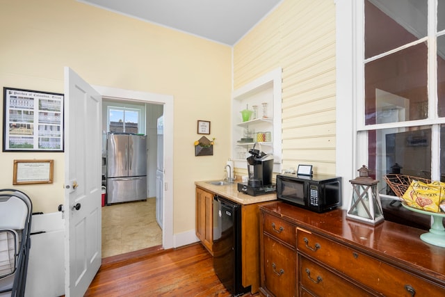 kitchen with black appliances, wood-type flooring, and sink