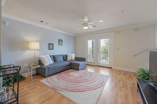 living room featuring crown molding, ceiling fan, and light hardwood / wood-style floors