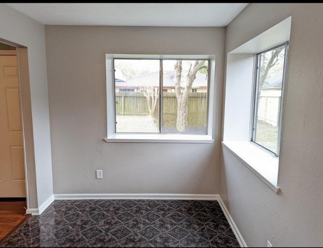 spare room featuring tile flooring and plenty of natural light