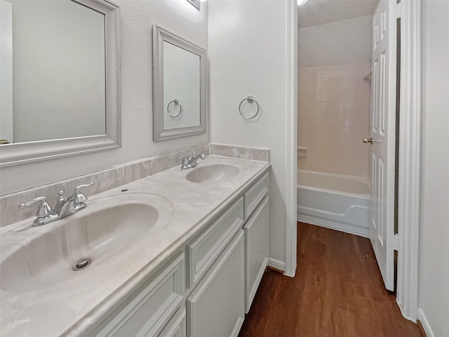 bathroom with hardwood / wood-style floors, vanity, and  shower combination