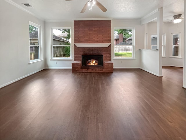 unfurnished living room featuring a fireplace, a textured ceiling, dark hardwood / wood-style flooring, and a wealth of natural light