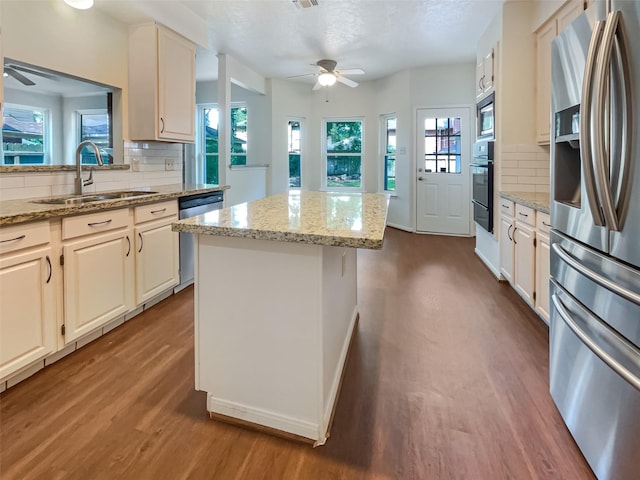 kitchen with tasteful backsplash, sink, a center island, and stainless steel appliances