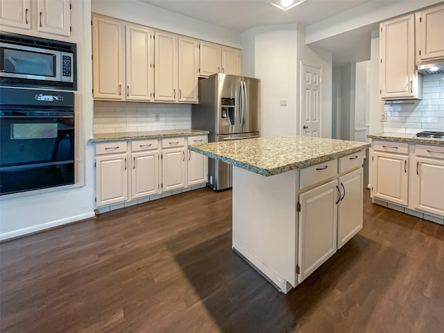 kitchen with backsplash, stainless steel appliances, a kitchen island, and dark wood-type flooring