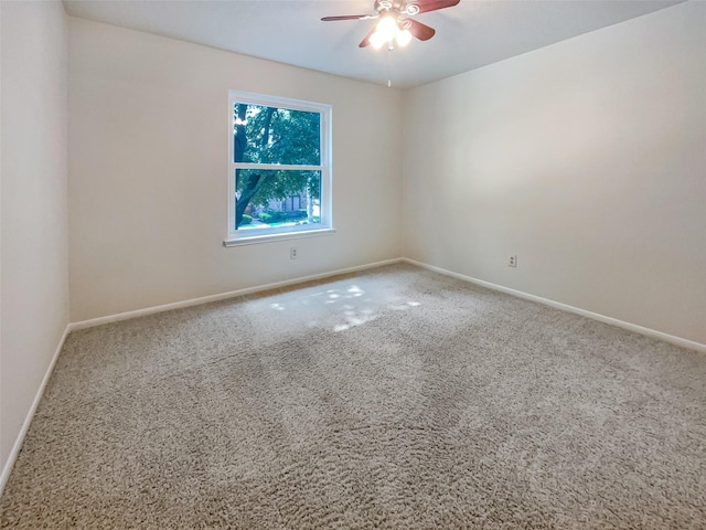 carpeted spare room featuring ceiling fan