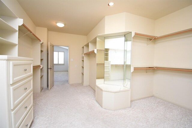 spacious closet featuring light colored carpet