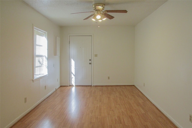 foyer entrance featuring a wealth of natural light, light wood-type flooring, and ceiling fan