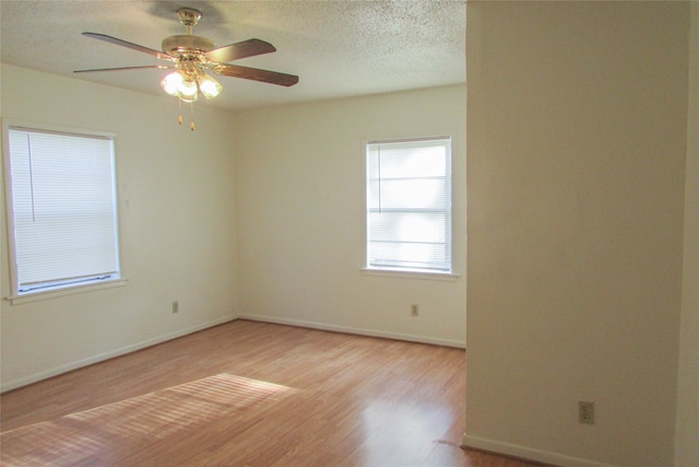 spare room featuring wood-type flooring, ceiling fan, and a textured ceiling