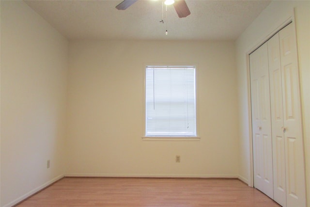 unfurnished bedroom featuring ceiling fan, a closet, and light hardwood / wood-style floors