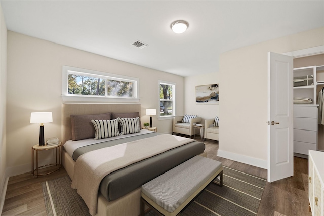 bedroom featuring dark hardwood / wood-style flooring and multiple windows