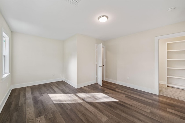 spare room featuring dark wood-type flooring