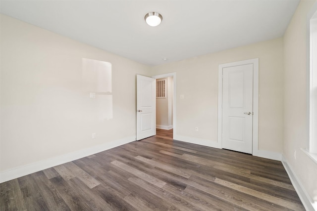 unfurnished bedroom with dark hardwood / wood-style floors and a closet