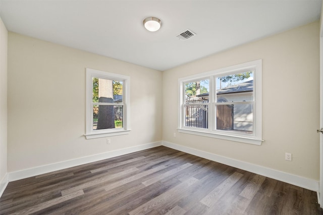 spare room with wood-type flooring and a healthy amount of sunlight