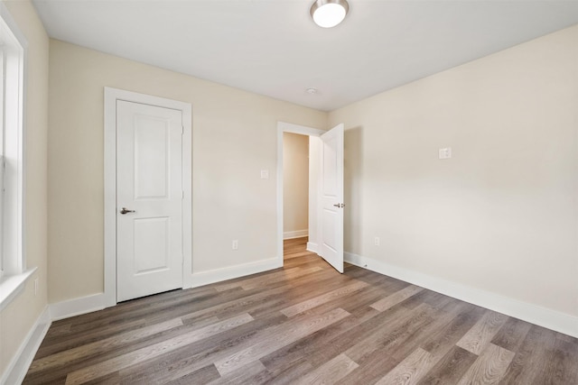 unfurnished bedroom with wood-type flooring and a closet